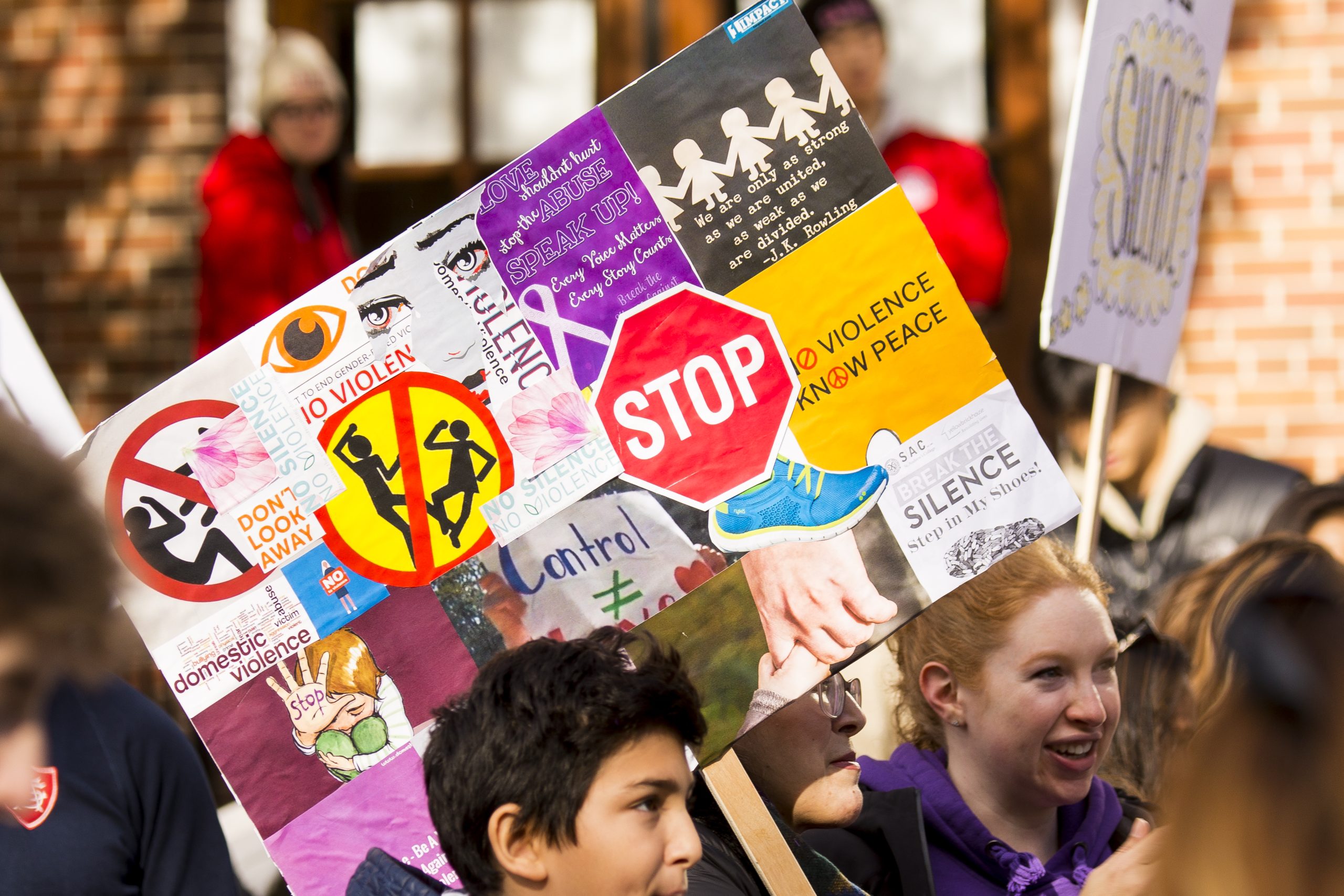 Walk participants holding signs with messages of support for survivors of domestic violence.